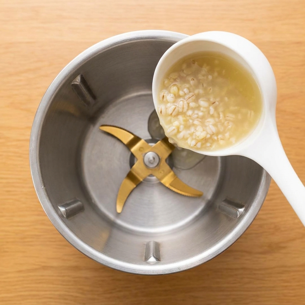 炊き上がった麦粥をミキサーの容器に注ぎ入れる様子。