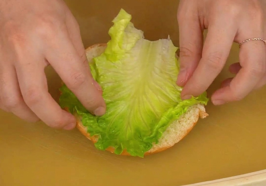 バンズの下半分にレタスとトマトをのせている様子