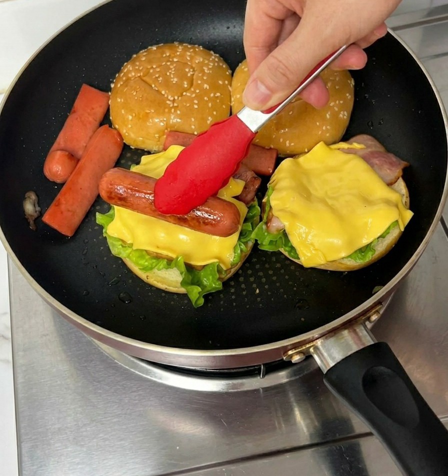 チーズの上に、焼いたソーセージをトングでのせている様子。