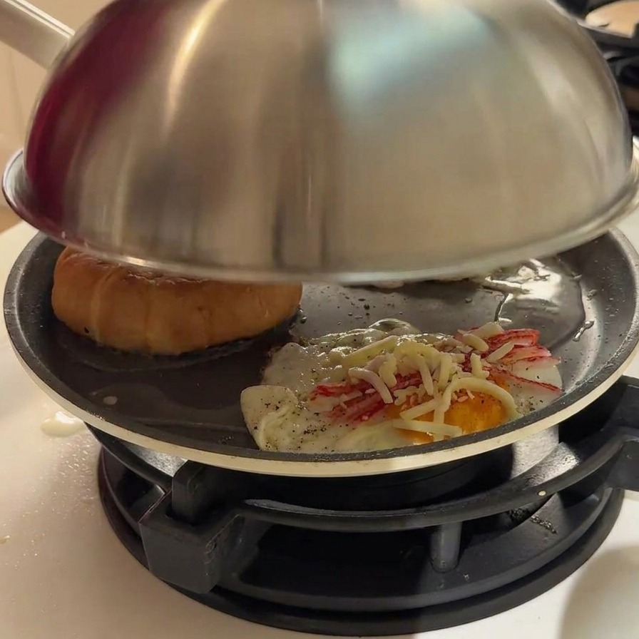 フライパンの蓋の隙間から蒸気が上がっている様子