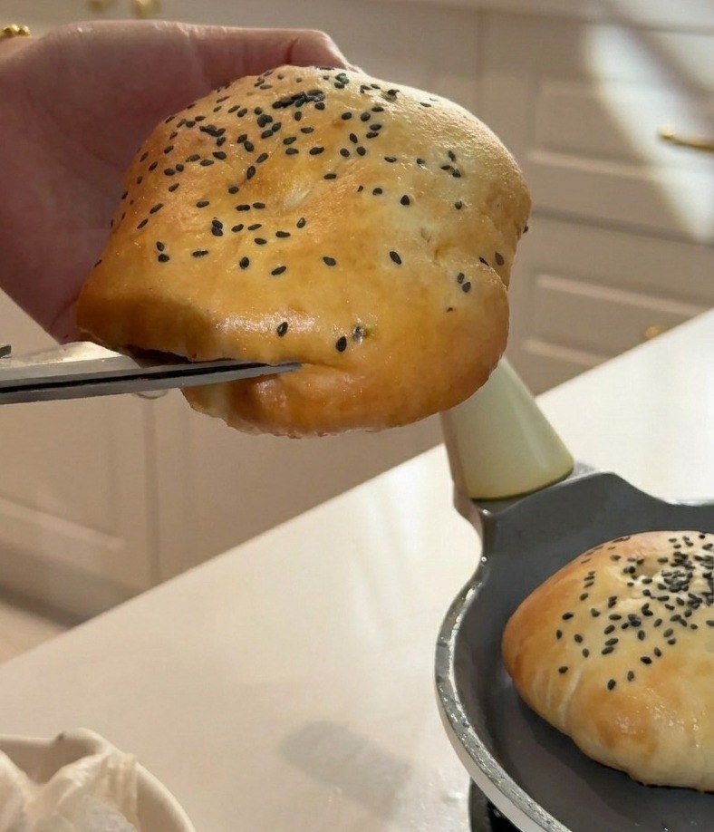 キッチンバサミを使って、ふわふわのバンズの側面に具材を挟むための切り込みを入れている様子