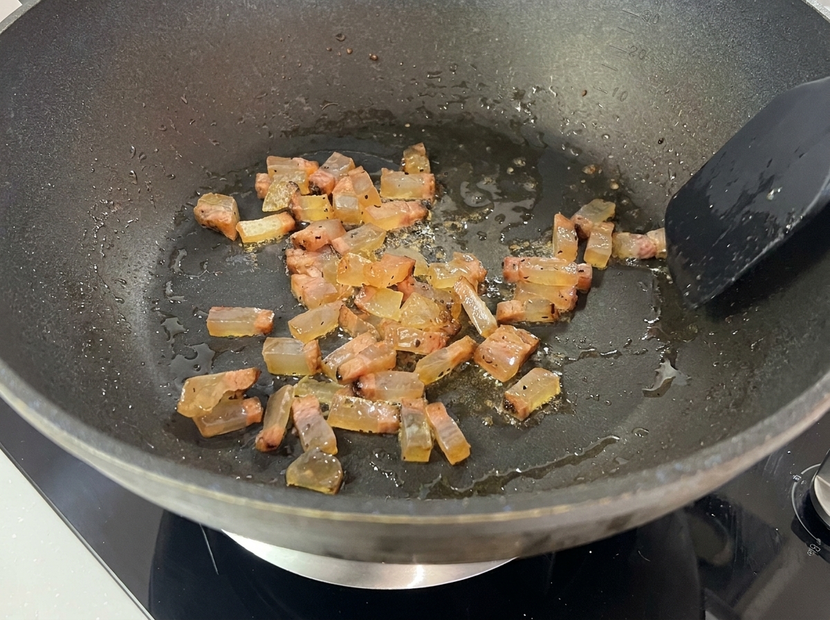 フライパンで自身の脂で揚げ焼きにされ、透明感を帯びて焼き色がついてきたグアンチャーレ。
