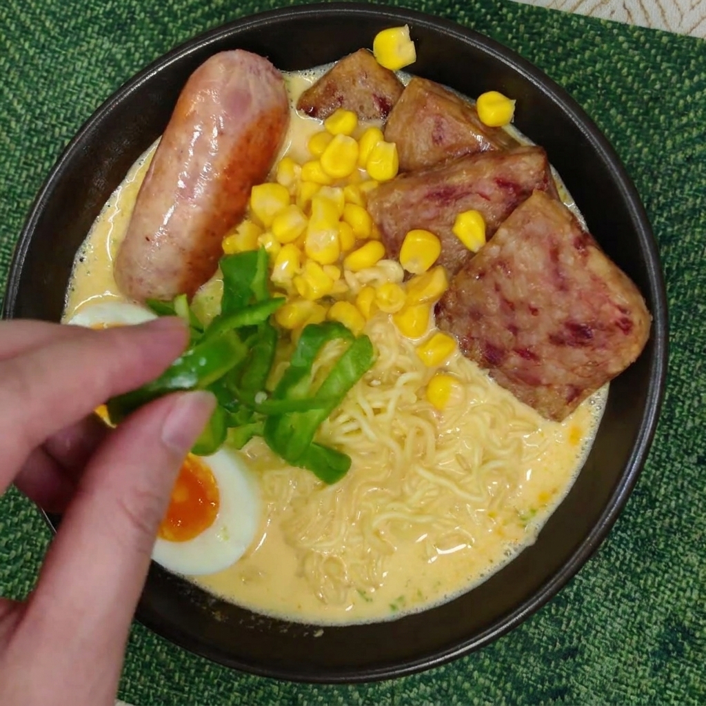 新鮮なピーマンのスライスをトッピングする様子