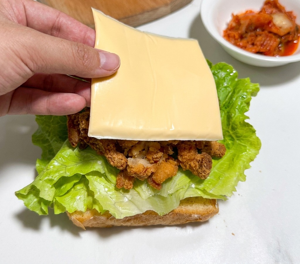 チキンの上にスライスチーズを乗せる様子。