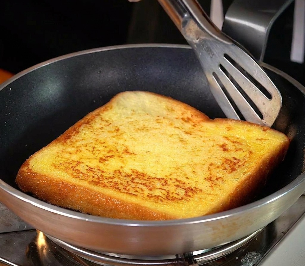 フライパンでバターとともに黄金色に焼ける厚切りトースト