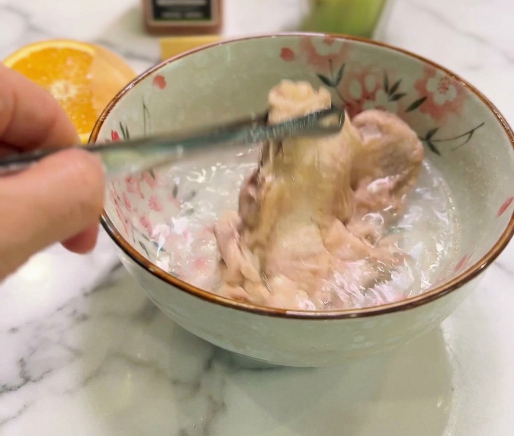 茹でた鶏肉を、ボウルに入れた冷水に浸して熱を取っている様子。