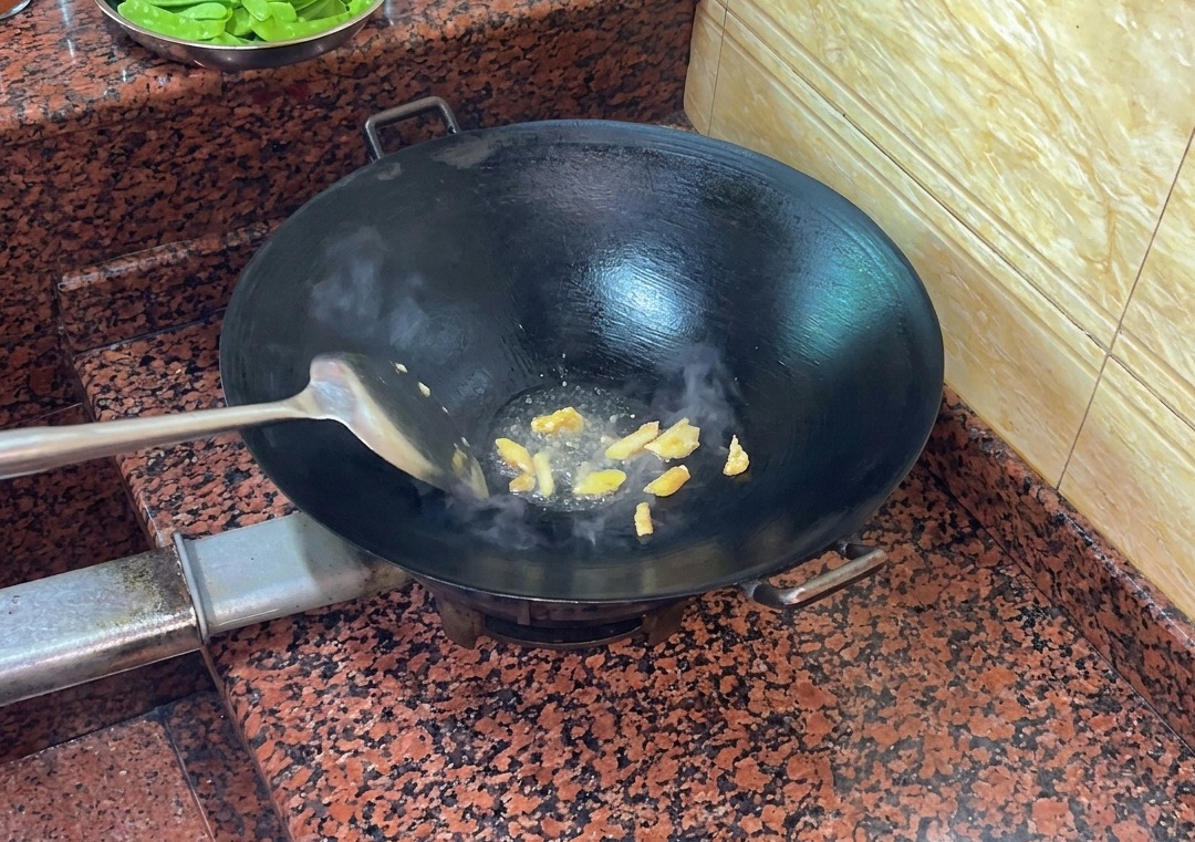 熱した中華鍋で、脂を出しながら炒められている鴨の皮。