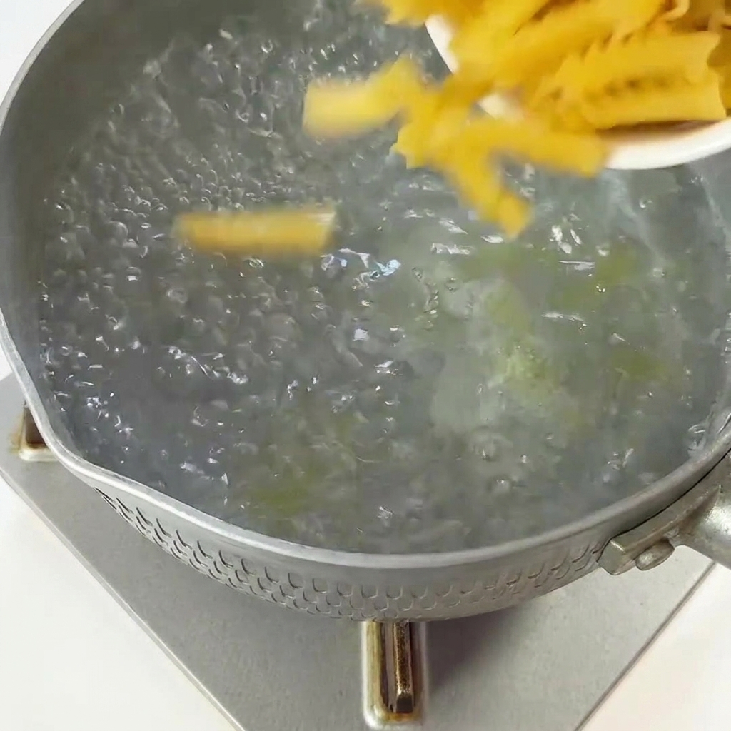 沸騰したお湯にフジッリパスタを入れている様子。