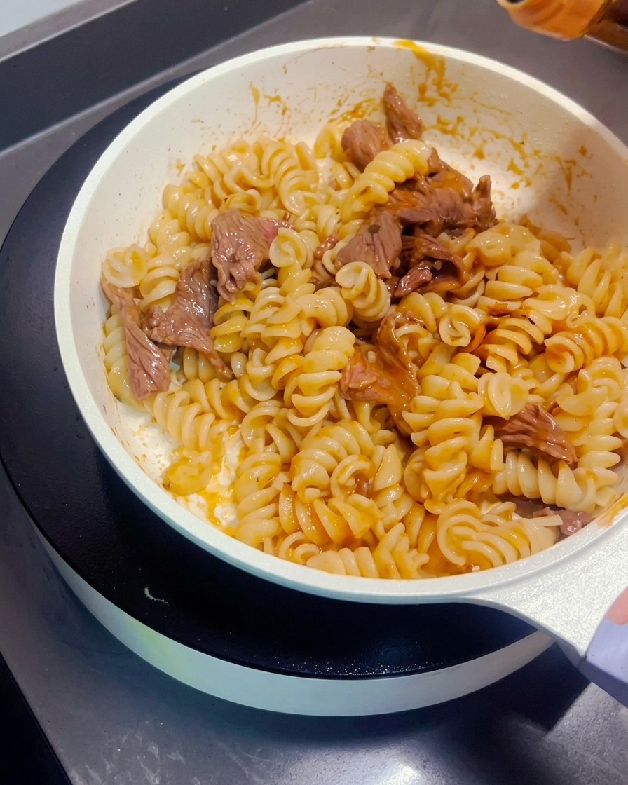 炒めたパスタの上にたまり醤油を少量回しかけている様子。
