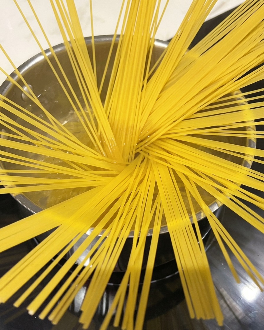 大きな鍋でパスタを茹でている様子。