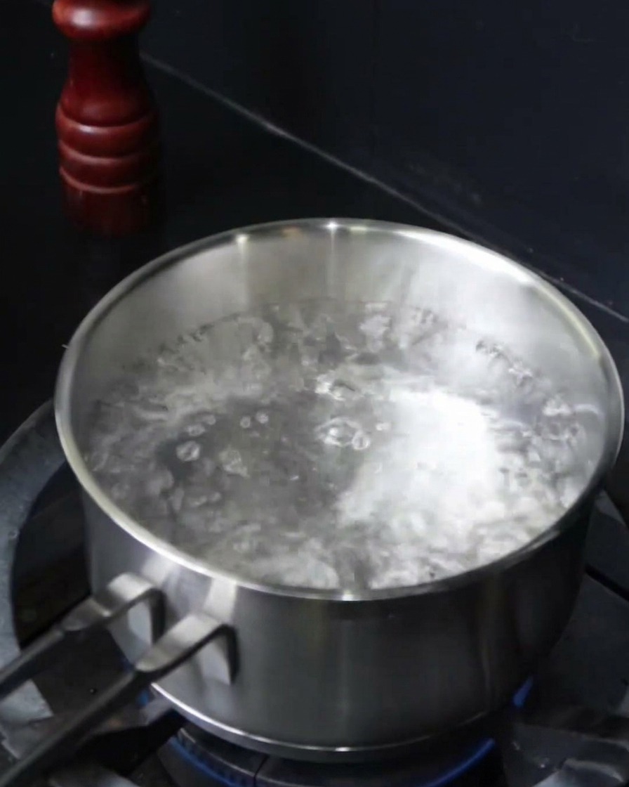沸騰した塩水にスパゲッティを投入している様子。