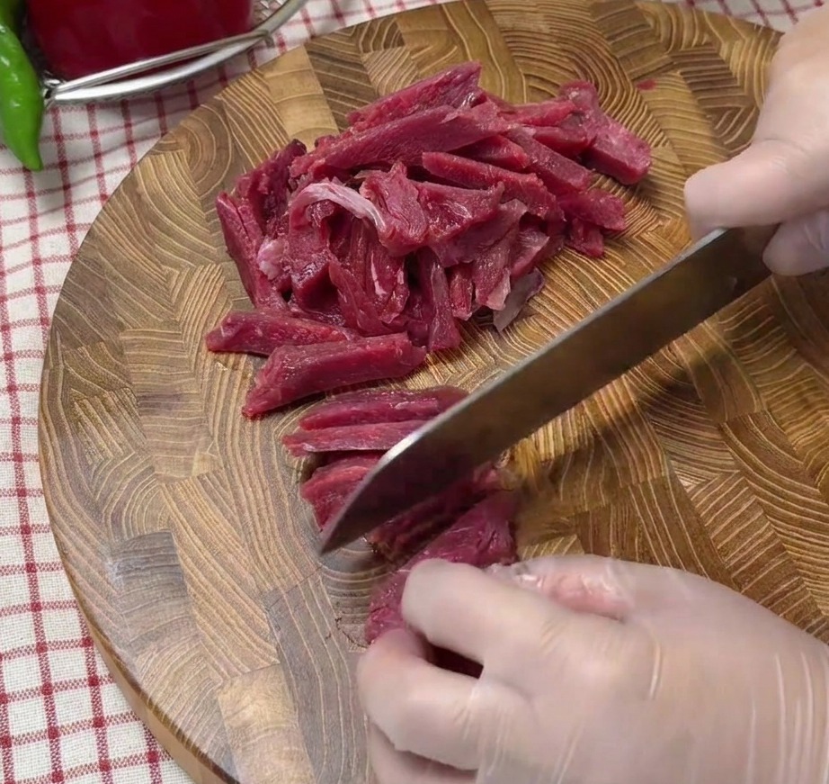 まな板の上にきれいに並べられた生の牛細切り肉。