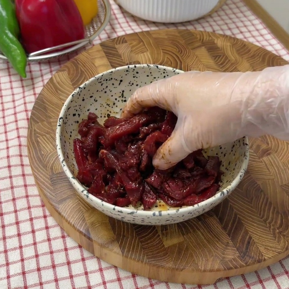 ボウルで醤油や調味料と和えられた生の牛細切り肉。