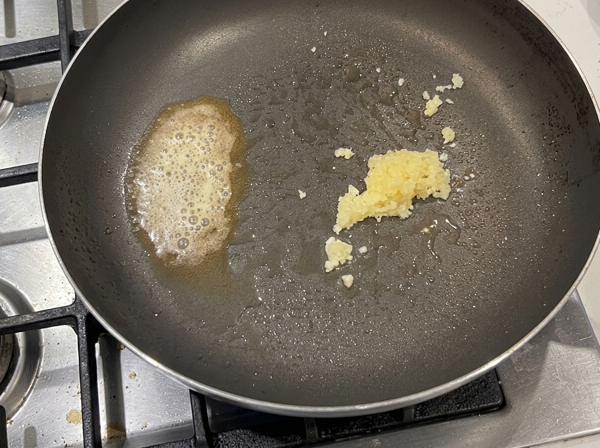 茹で上がったパスタをフライパンに投入している様子。