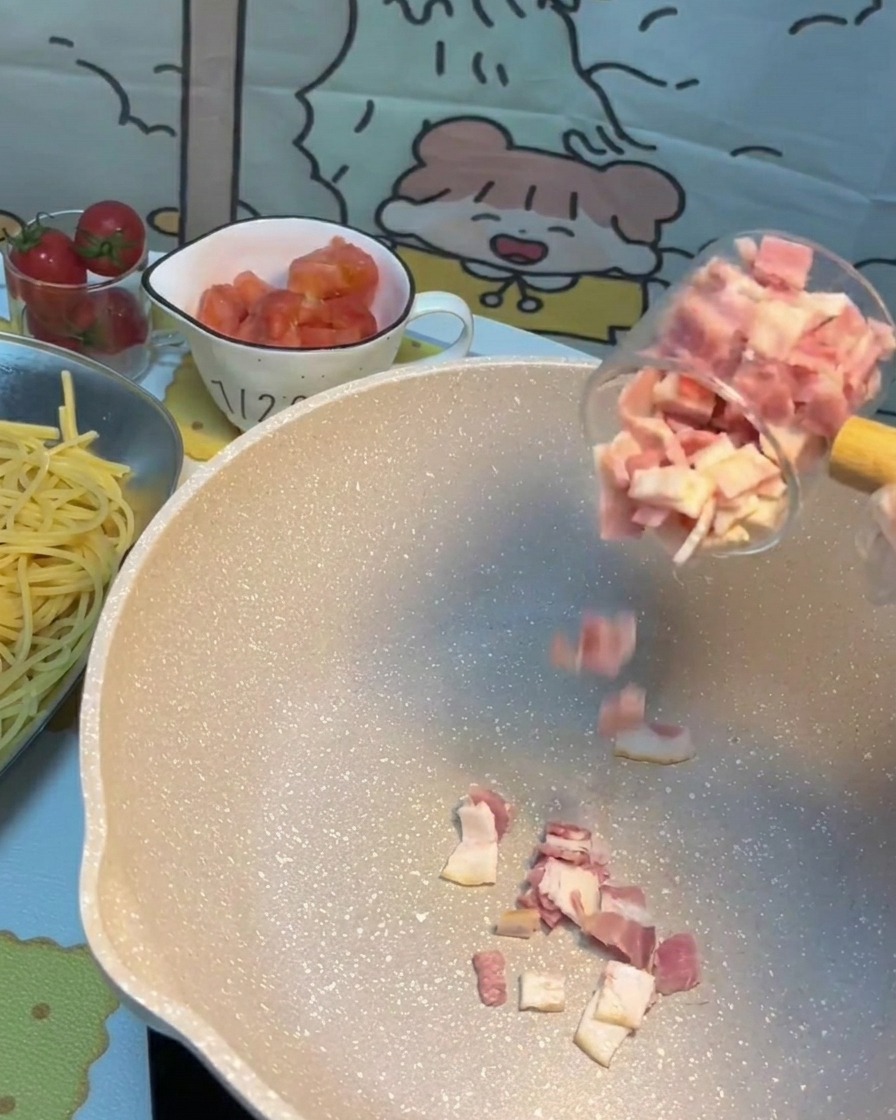 フライパンでベーコンがこんがりと焼けている様子。