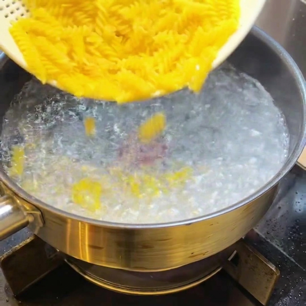 沸騰したお湯に乾燥フジッリを入れる様子