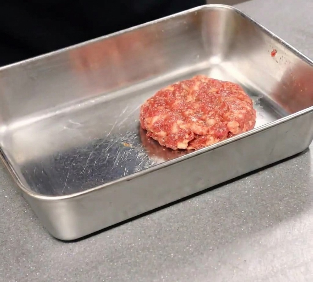 焼き上がったピザを、ピザカッターで切り分けている様子。