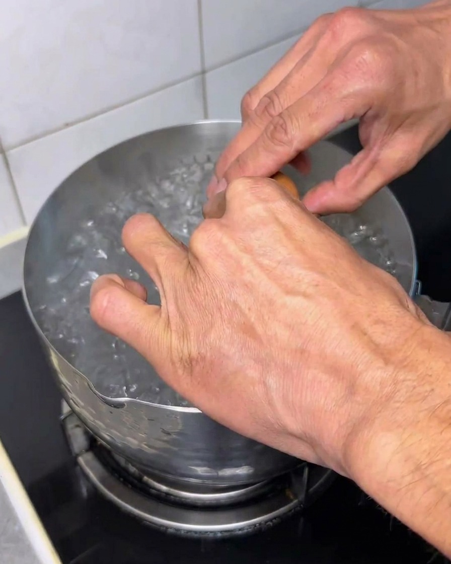 沸騰した鍋に卵を割り入れている様子。
