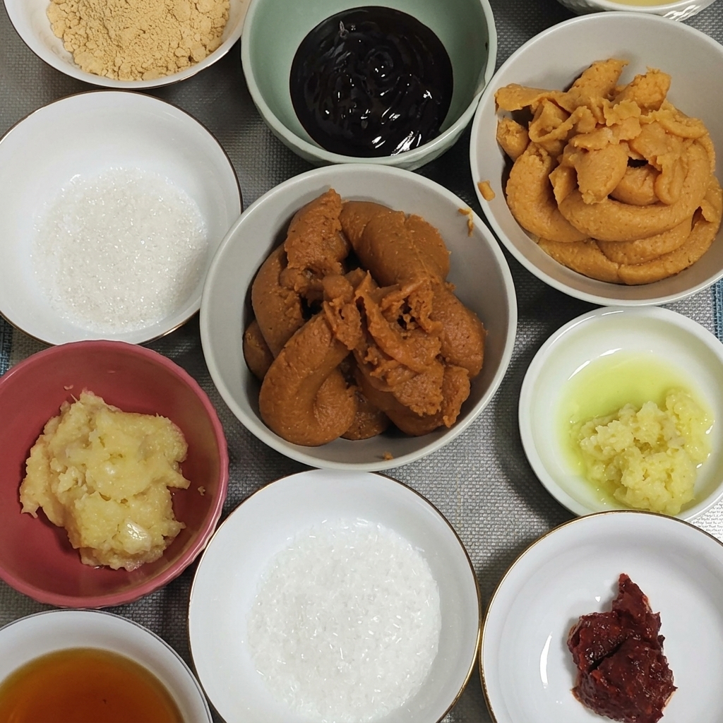にんにくと生姜が入った鉢に、たっぷりの赤味噌を加えている様子。
