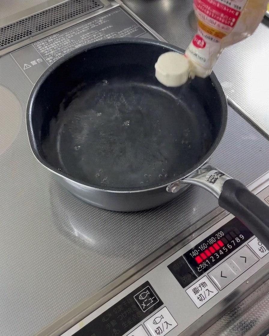 水が入った鍋に料理酒とみりんが注がれている様子。