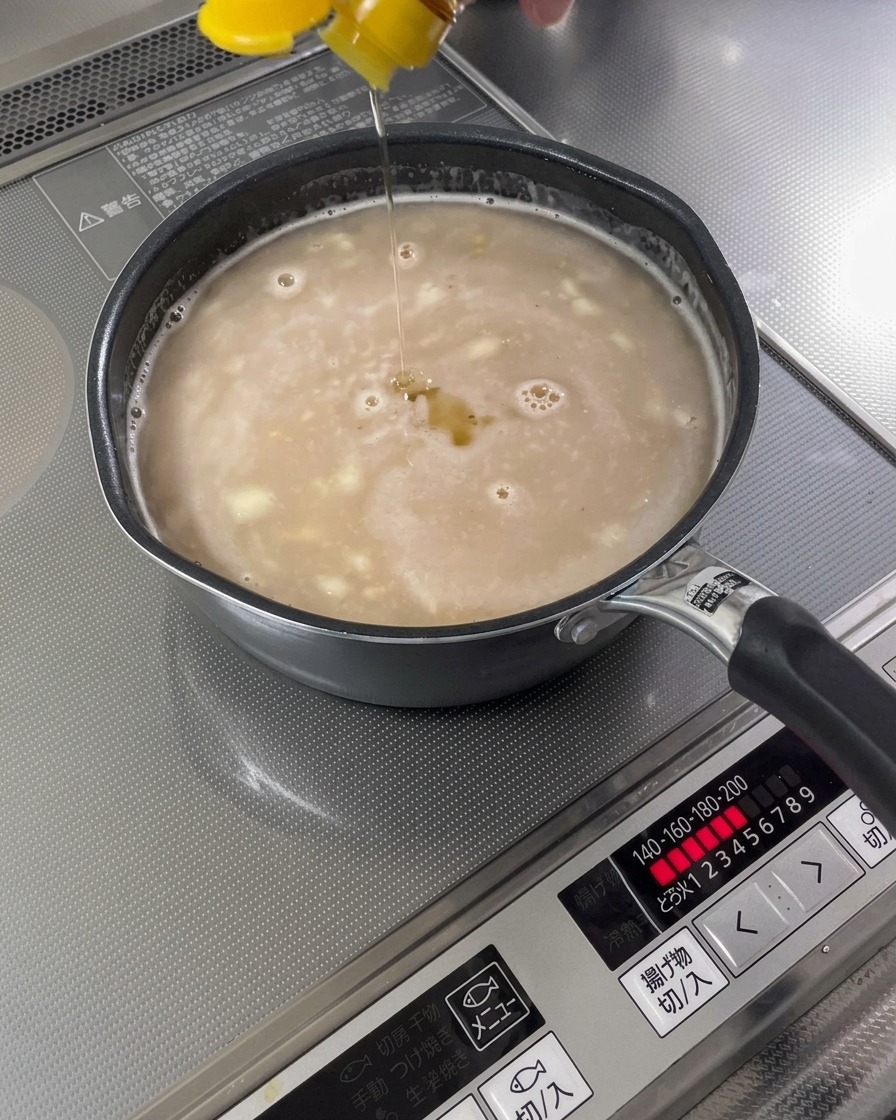完成したスープベースにごま油が回し入れられている様子。
