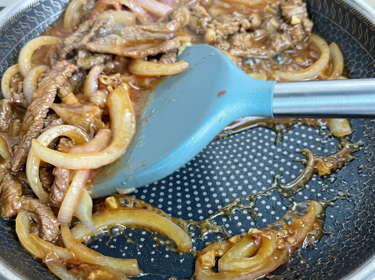 フライパンの中でタレと具材が煮絡められている様子。