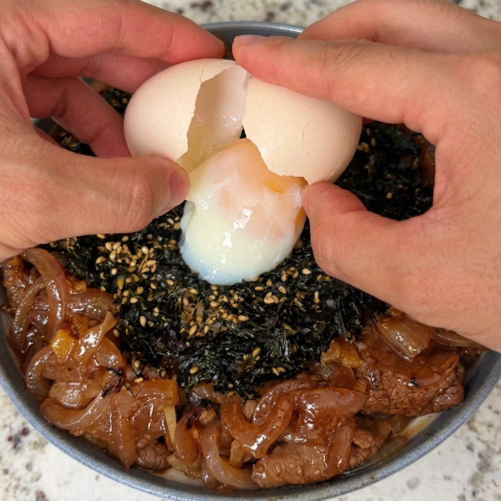 完成した牛丼に温泉卵が乗っているクローズアップ写真。