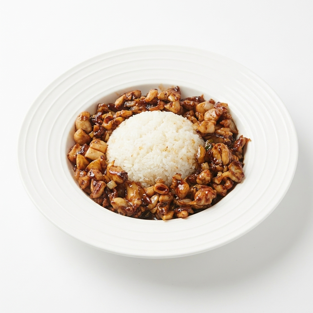 盛り付けたご飯の周りに、炒めた鶏肉をきれいに盛り付けている様子。