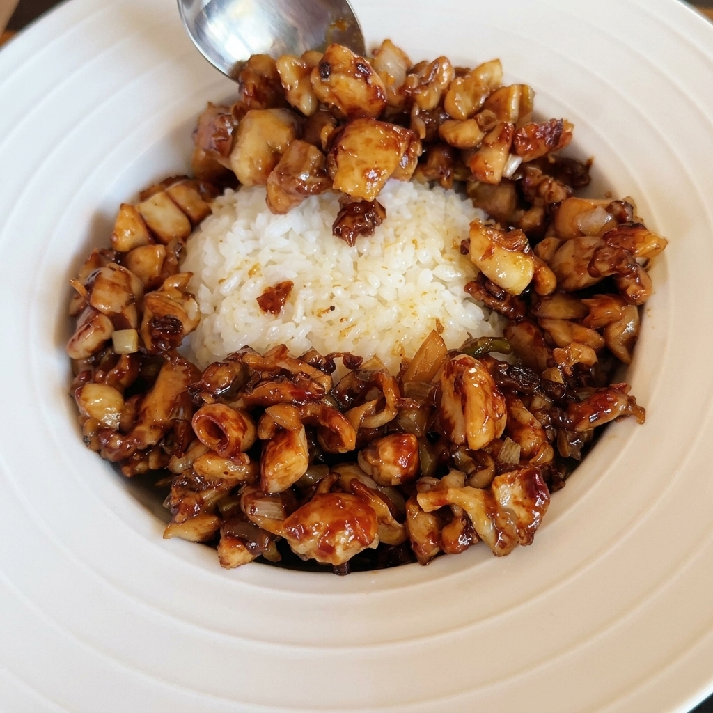どんぶりの中央に焼いた目玉焼きをのせている様子。