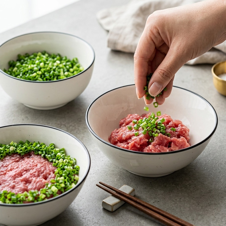 ねぎとろ丼の周りに刻みねぎをトッピングしているアップ写真。
