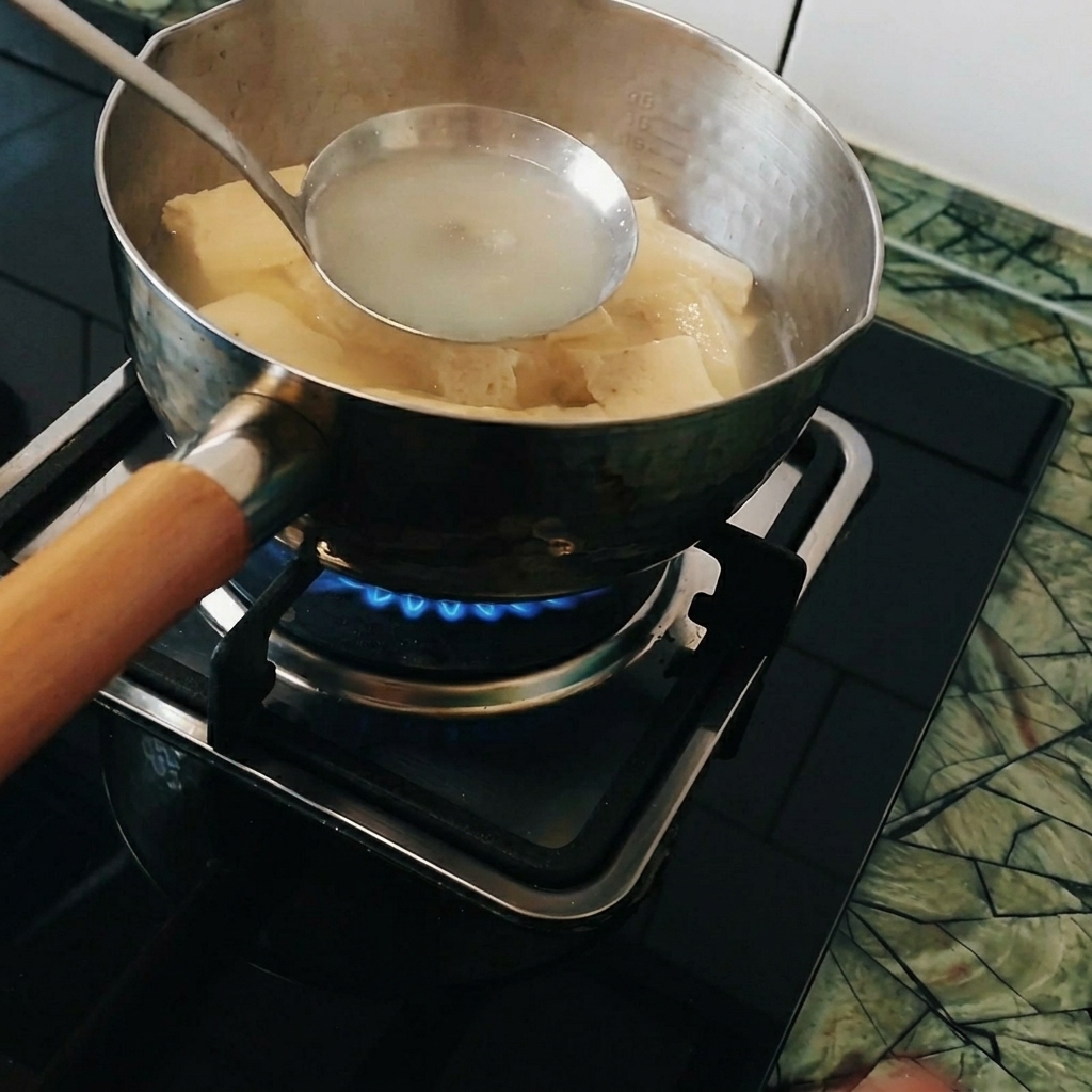沸騰した鍋の中で、お玉に入れたカレールーを溶かしている様子