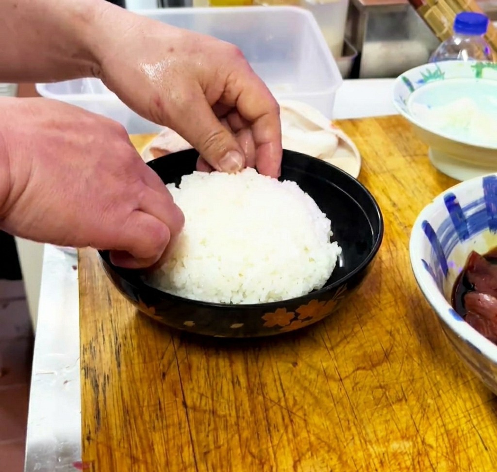 器に盛られたご飯を、平らにならしている様子。