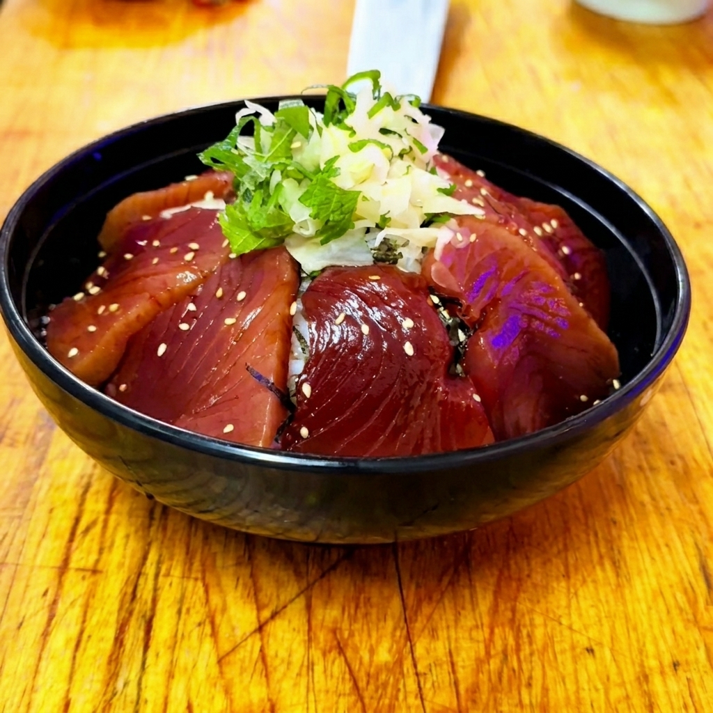 完成したマグロ漬け丼に、白ごまを振っている様子。