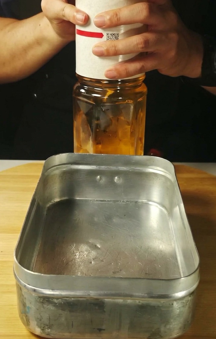 金属製のバットに酒とみりんを注いでいる様子。