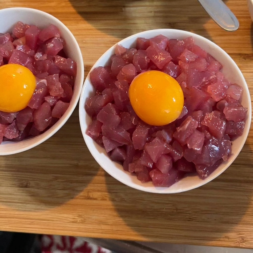マグロの上にのった黄金色の卵黄と、鮮やかな緑の刻みネギ。