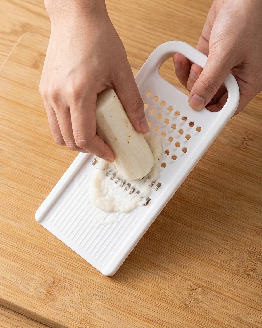 プラスチック製のおろし器ですりおろされた、真っ白な長芋のペースト。