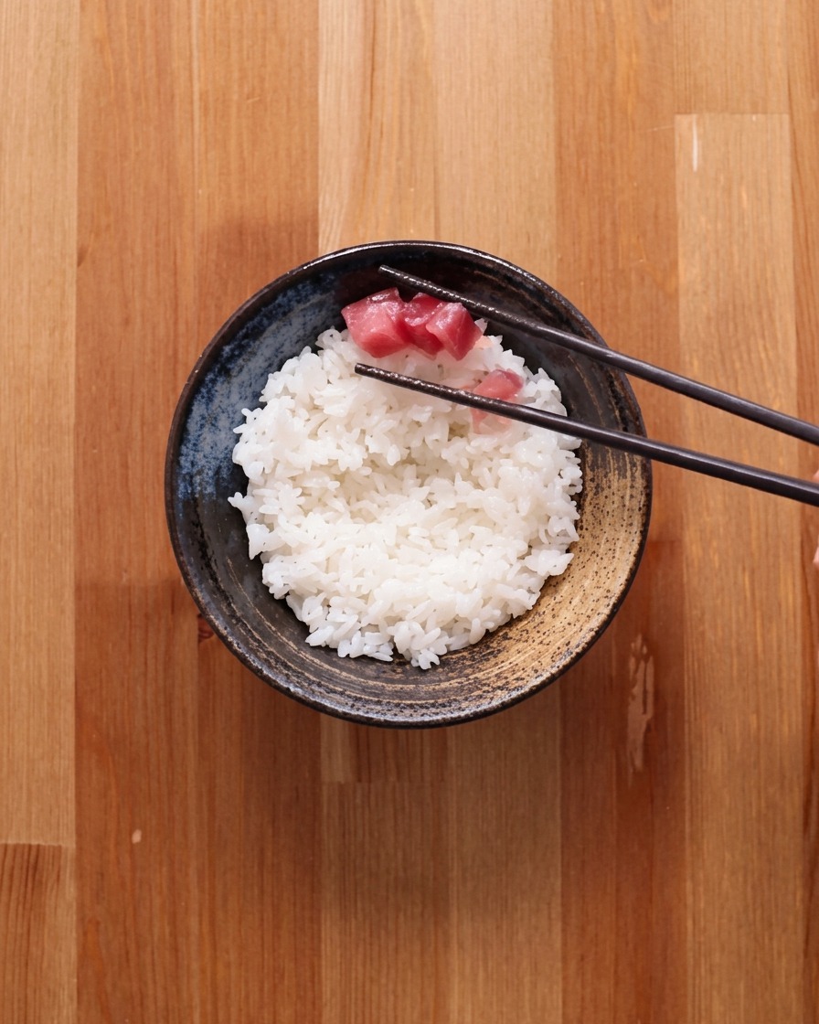 白飯の上に、角切りまぐろをきれいに盛り付けている様子。