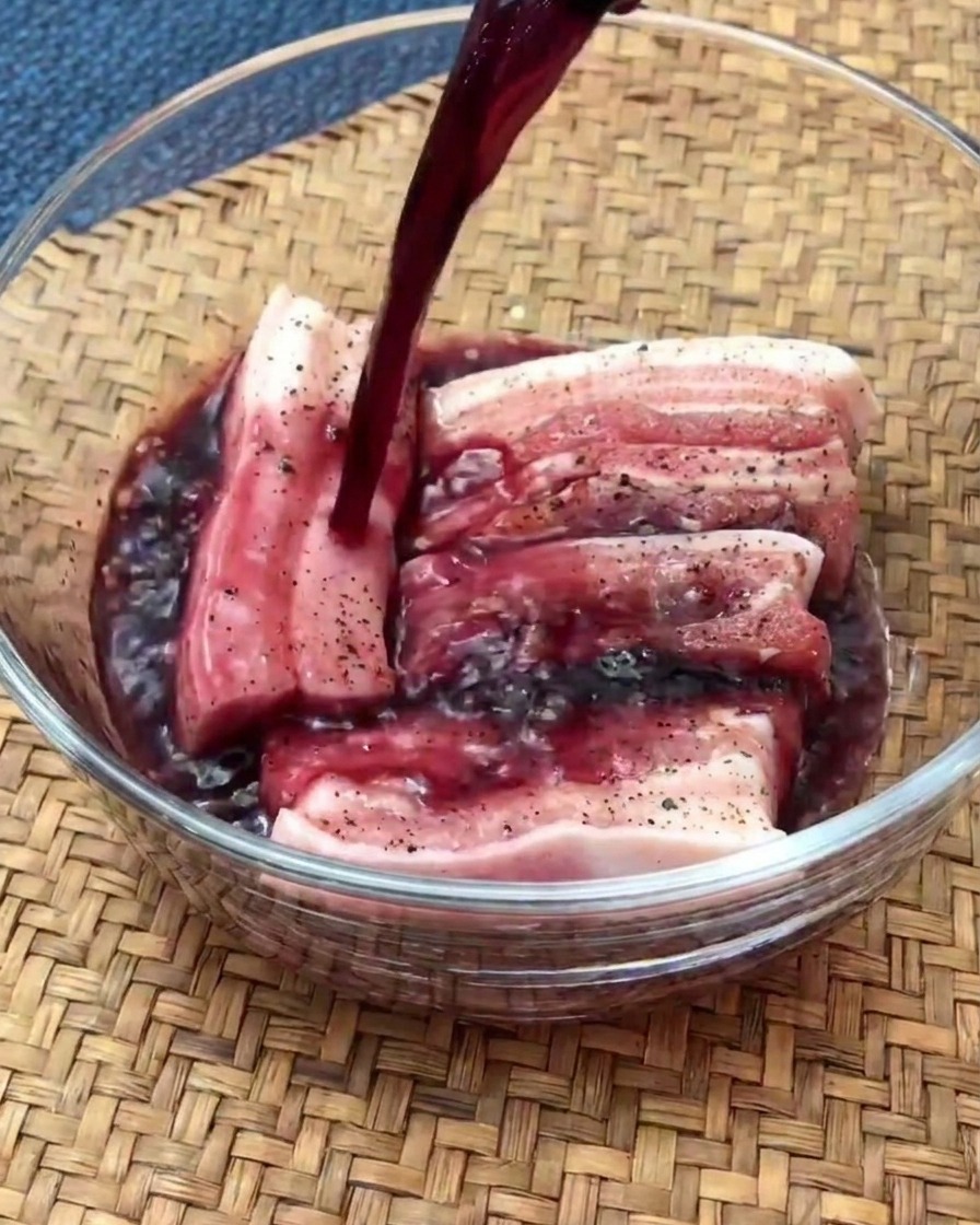 赤ワインを入れたガラスボウルでマリネ中の豚バラ肉スライス。