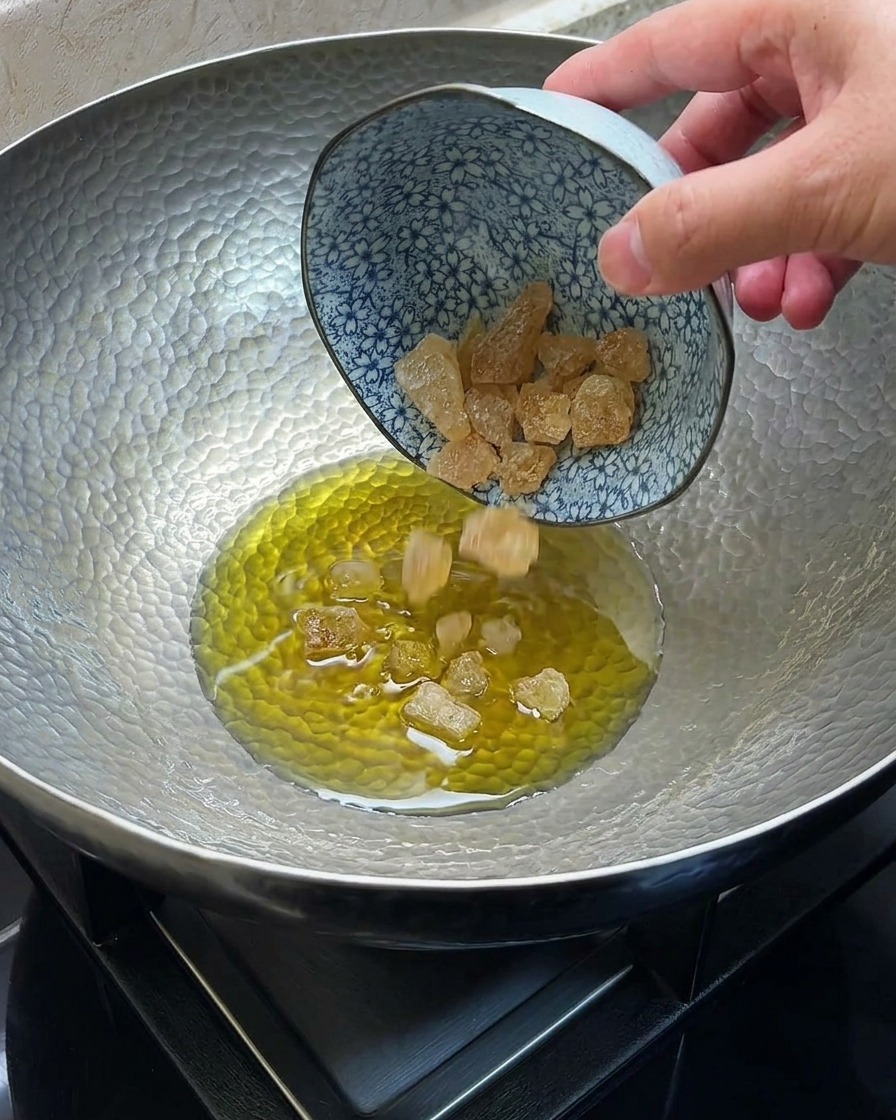 中華鍋で氷砂糖を油で溶かしてキャラメル状にしている様子