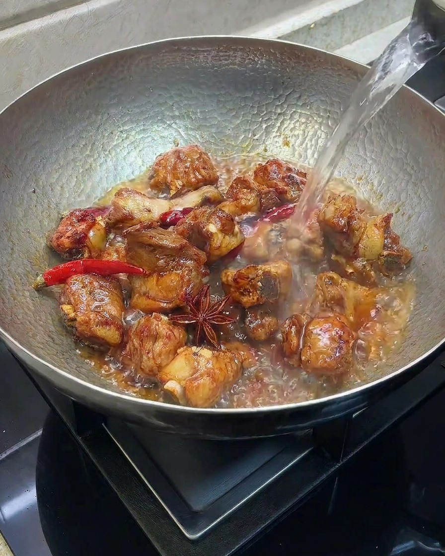 肉が浸る程度の熱湯を鍋に注いでいる様子
