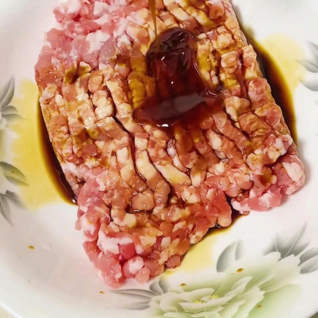 下味をつけたひき肉にオイスターソースを加えている様子。