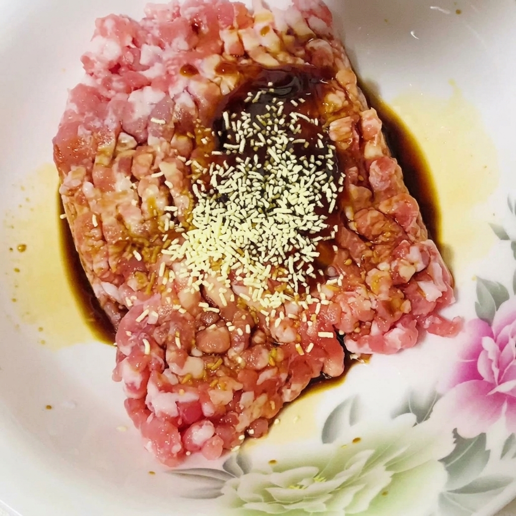 ソースとひき肉のタネにスパイスを加えている様子。