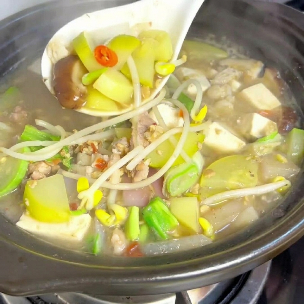 熱した土鍋で豚バラ肉を炒めている様子。