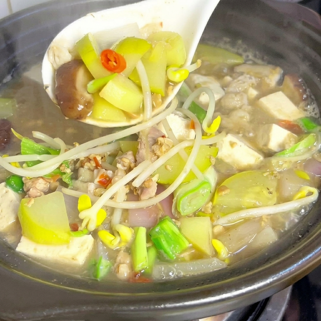 沸騰したスープにズッキーニとしいたけを入れている様子。