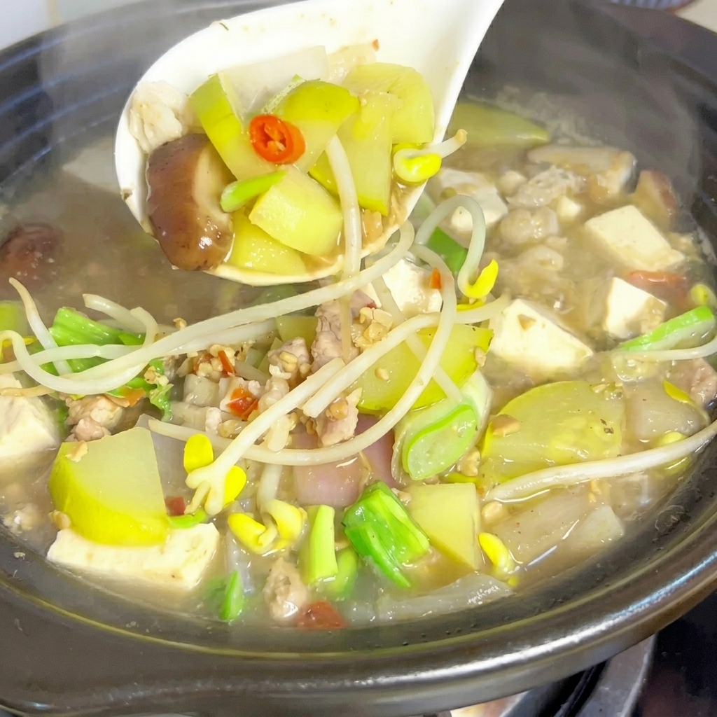 お玉で豆腐や具材をすくい上げている様子。