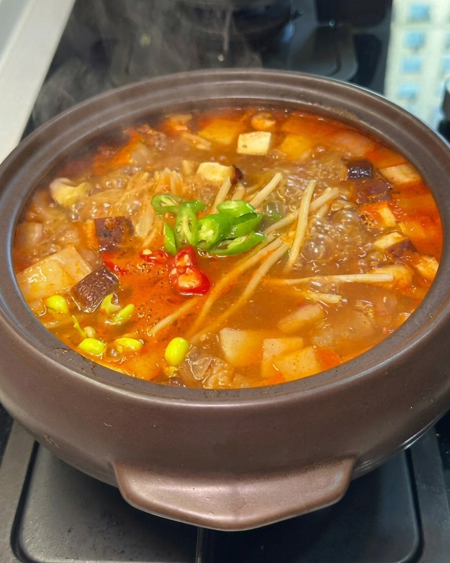 スライスした青唐辛子と赤唐辛子が、野菜の上で散らされている様子。