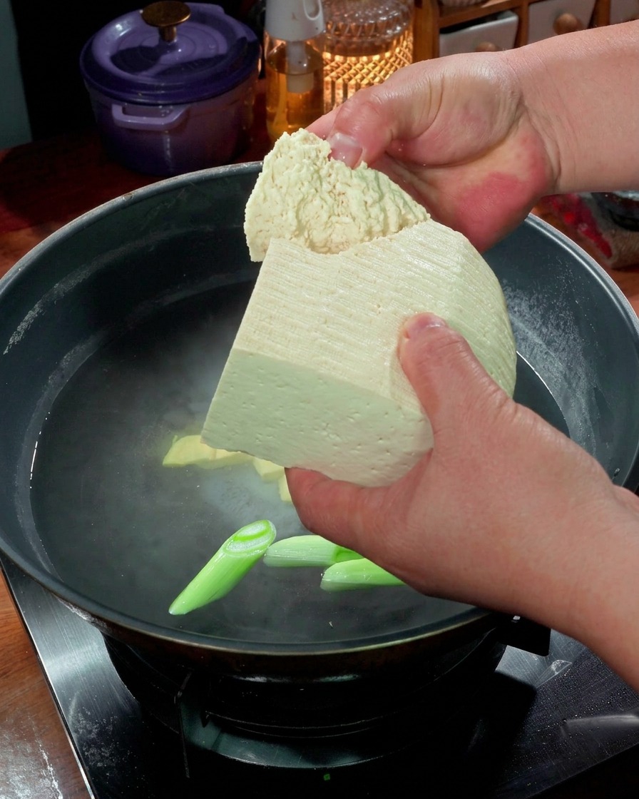 沸騰した湯の中で豆腐を煮ている様子。