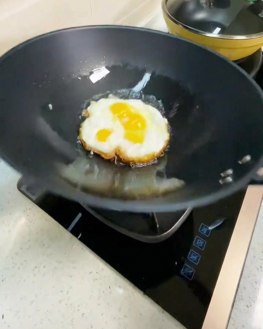 フライパンの中で卵を裏返し、焼き色がついている様子。