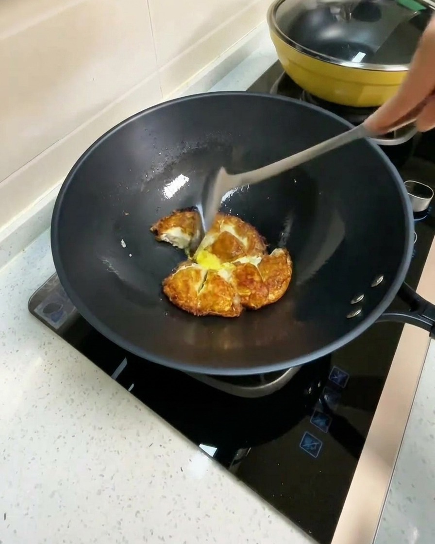 焼いた卵が入ったフライパンに熱湯を注いでいる様子。