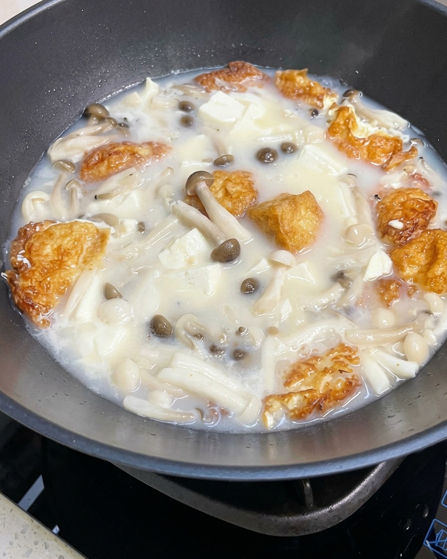 スープに塩と胡椒で味付けをしている様子。